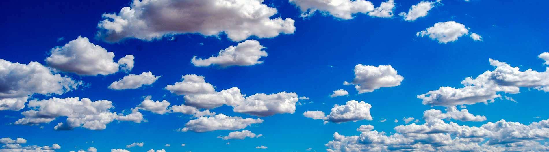 Tiefblauer Himmel mit lockeren, weißen Wolken